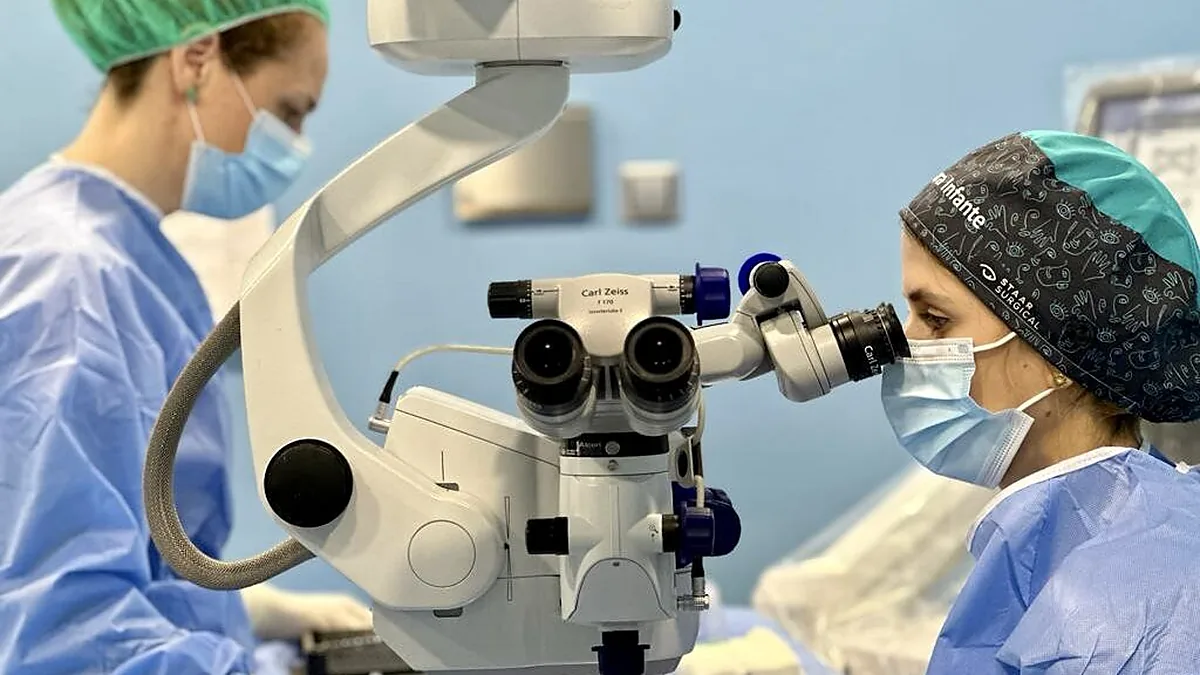 Equipo quirúrgico trabajando con el microscopio en el quirófano
